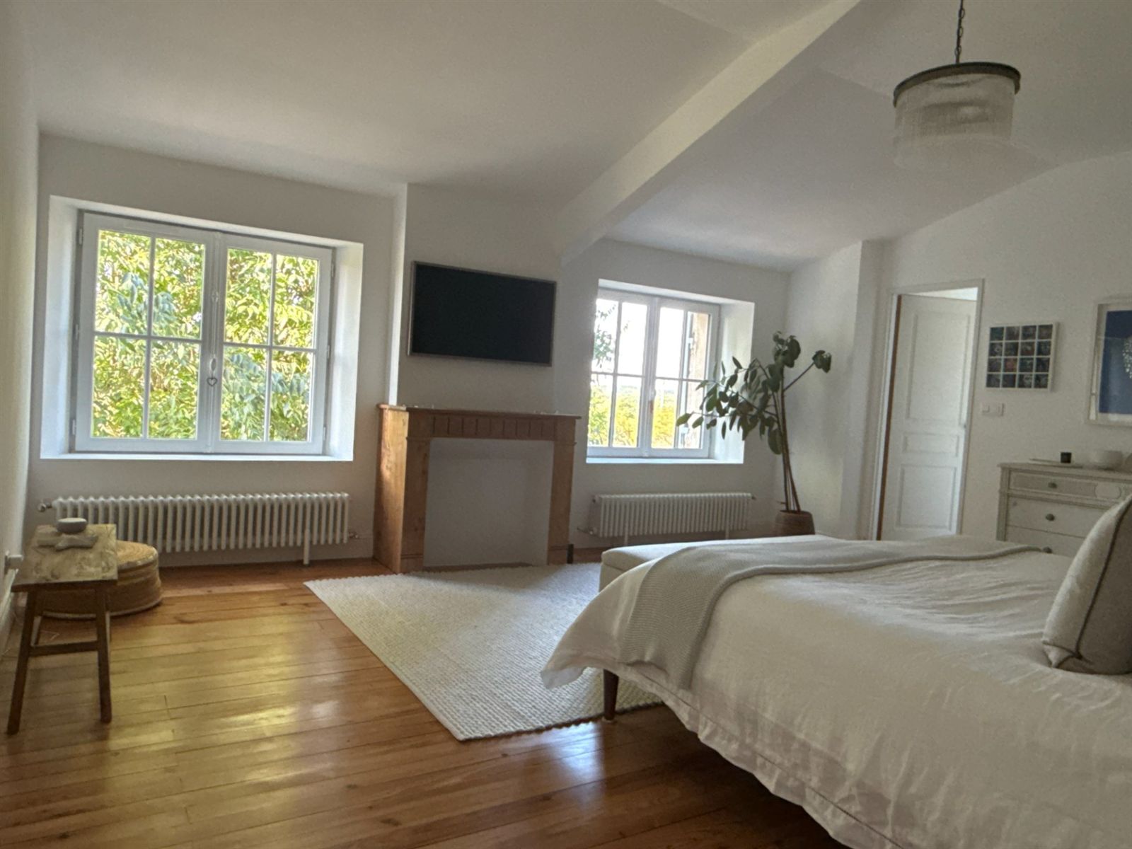 Master bedroom with fireplace, garden windows and upholstered bed