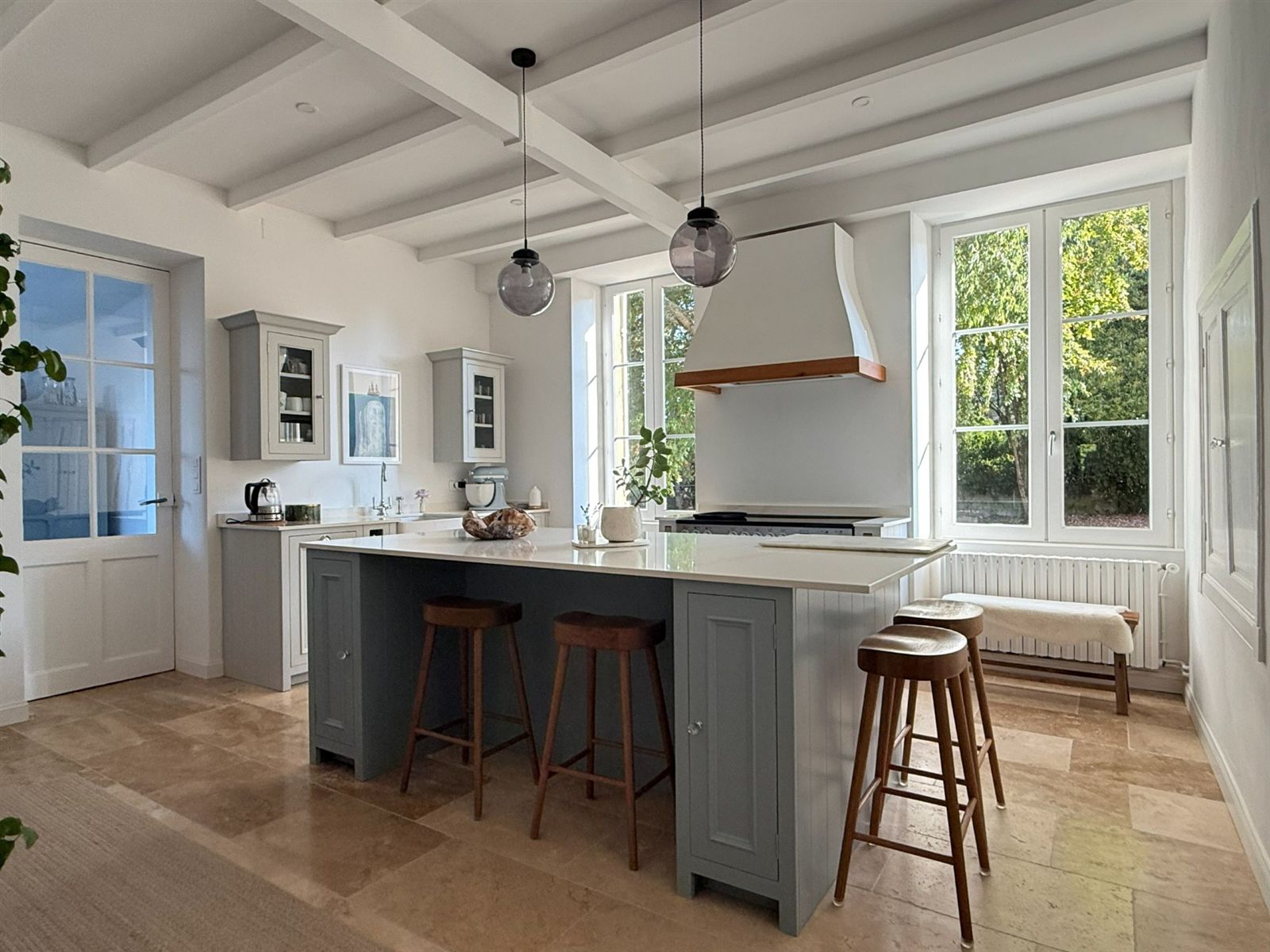 The light-filled kitchen with painted island and old fireplace